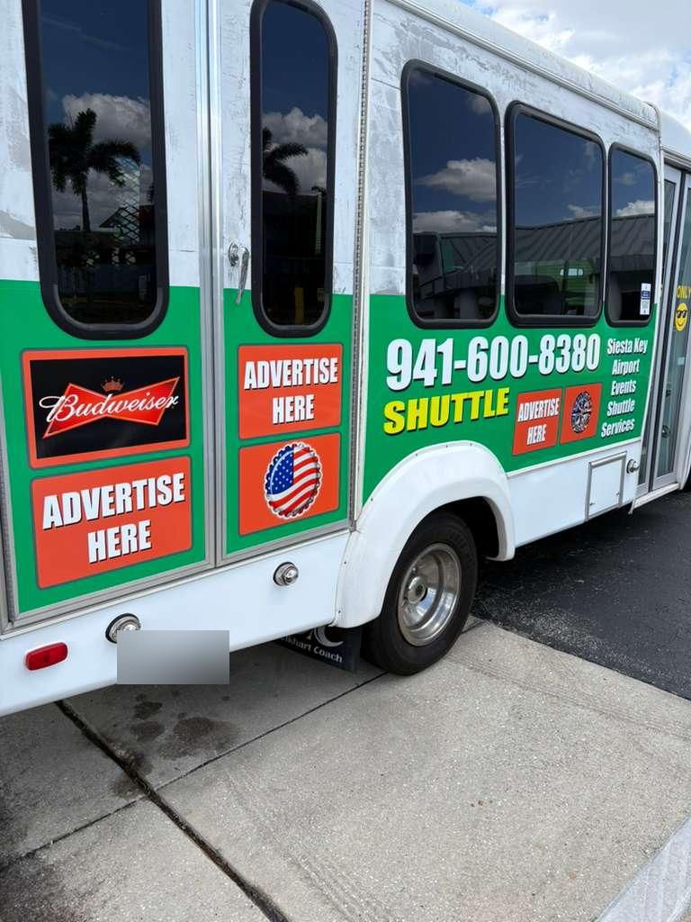 White and green shuttle with Budweiser advertising